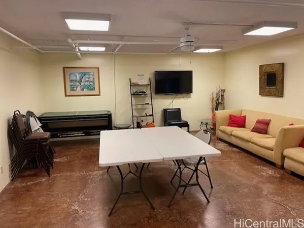 a living room with furniture a flat screen tv and kitchen view