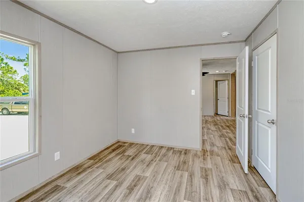 a view of a room with wooden floor and a window