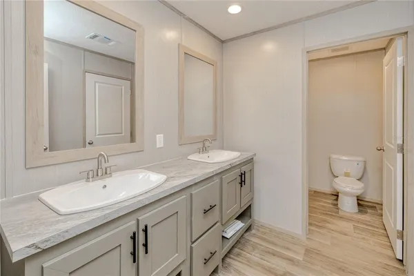 a bathroom with a granite countertop sink a toilet and a mirror