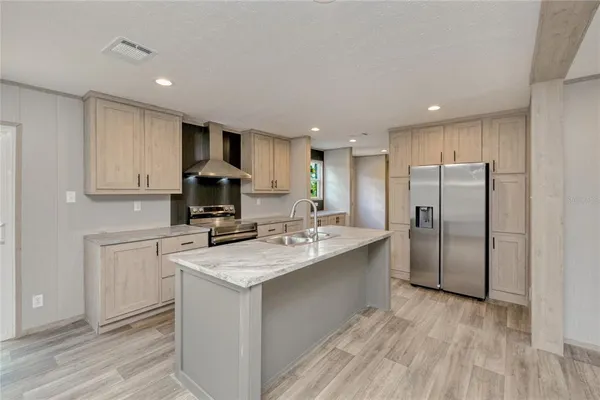 a kitchen with kitchen island a sink stainless steel appliances and white cabinets