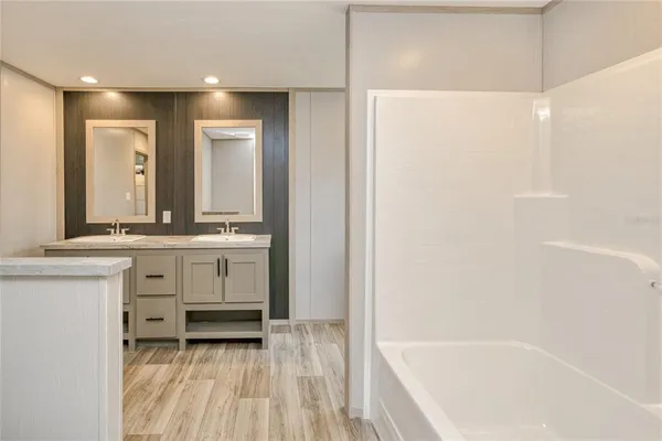 a bathroom with a bathtub a sink and a mirror