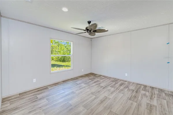 an empty room with windows and fan