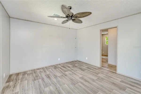 a view of a room with wooden floor and a ceiling fan