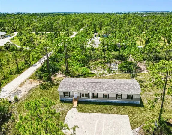 a view of a house with a big yard and large trees