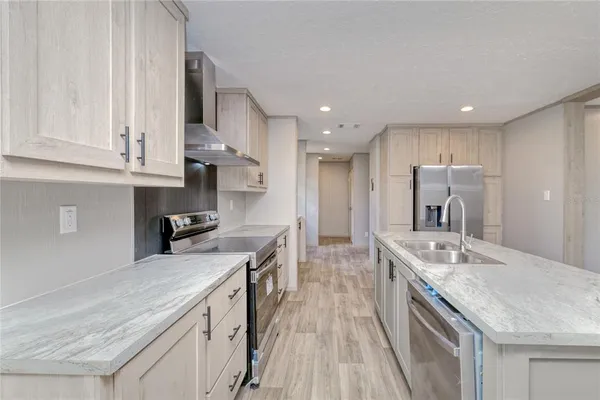 a kitchen with stainless steel appliances granite countertop a sink stove and refrigerator