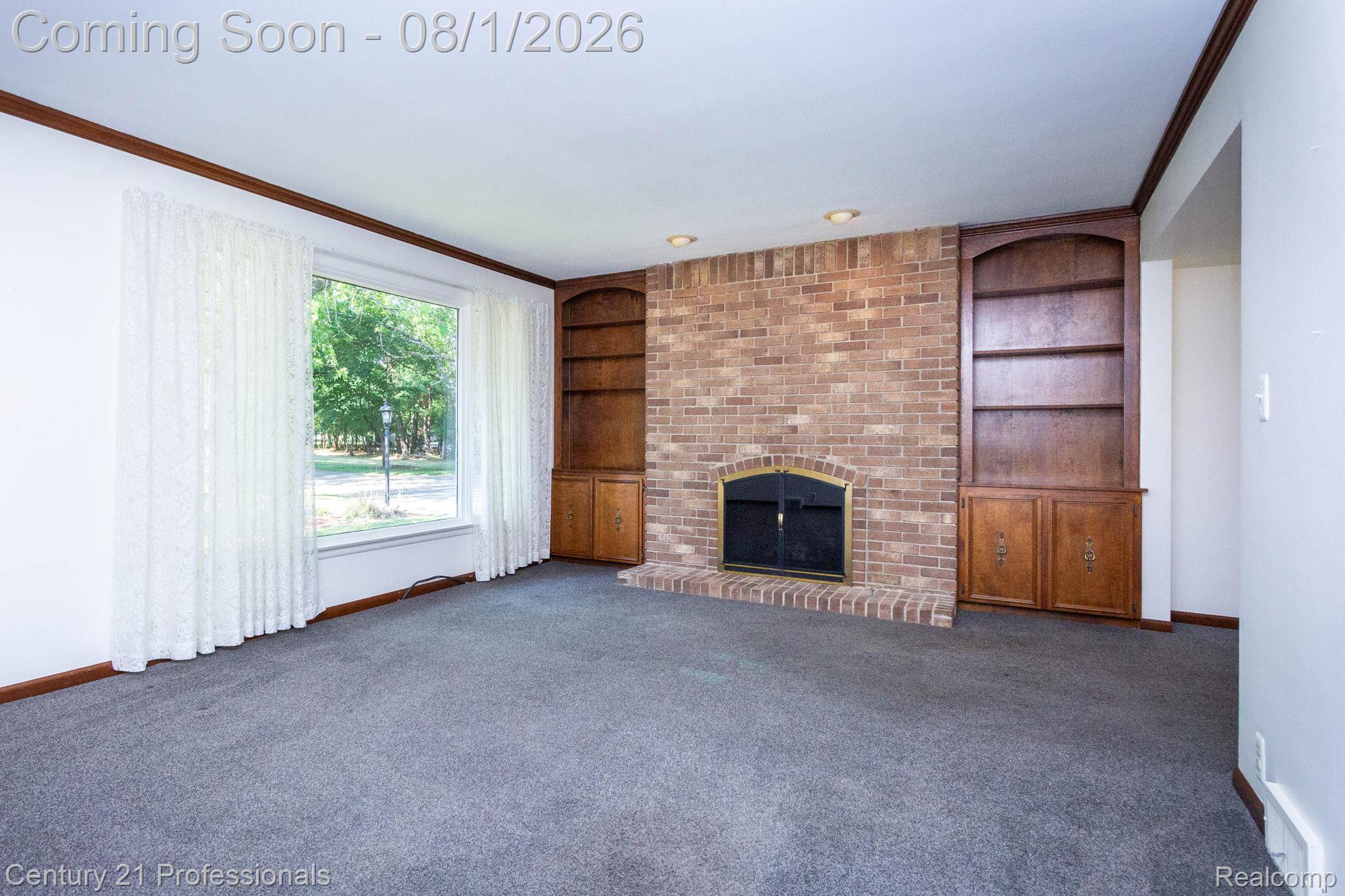 1365 East Buell Road Rochester, MI 48306 - Photo 6 of 56 Brick fireplace with a brass-trimmed firebox, flanked by built-in wood cabinetry and shelving