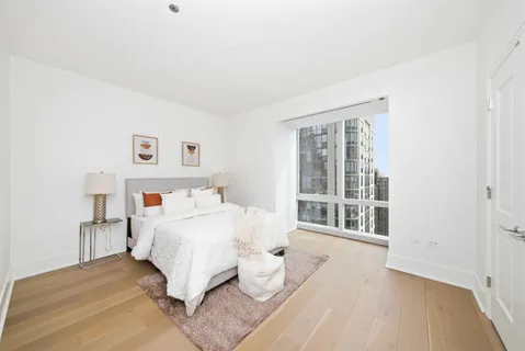 a bedroom with a bed and a large window