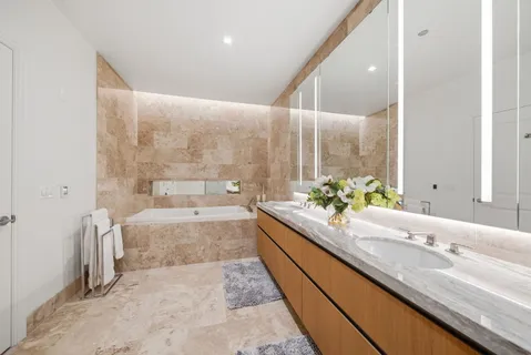 a large bathroom with a granite countertop tub a sink and a large mirror