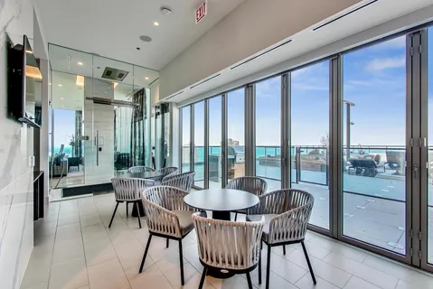 a dining room with furniture and a floor to ceiling window