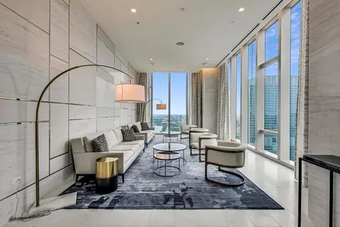 a living room with patio furniture and a rug