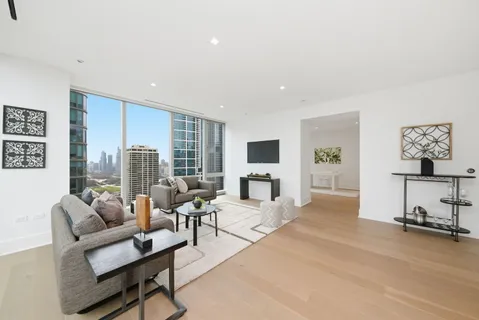 a living room with furniture a large window and a flat screen tv