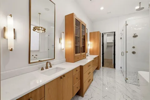 a spacious bathroom with a double vanity sink a large mirror a shower and a bathtub