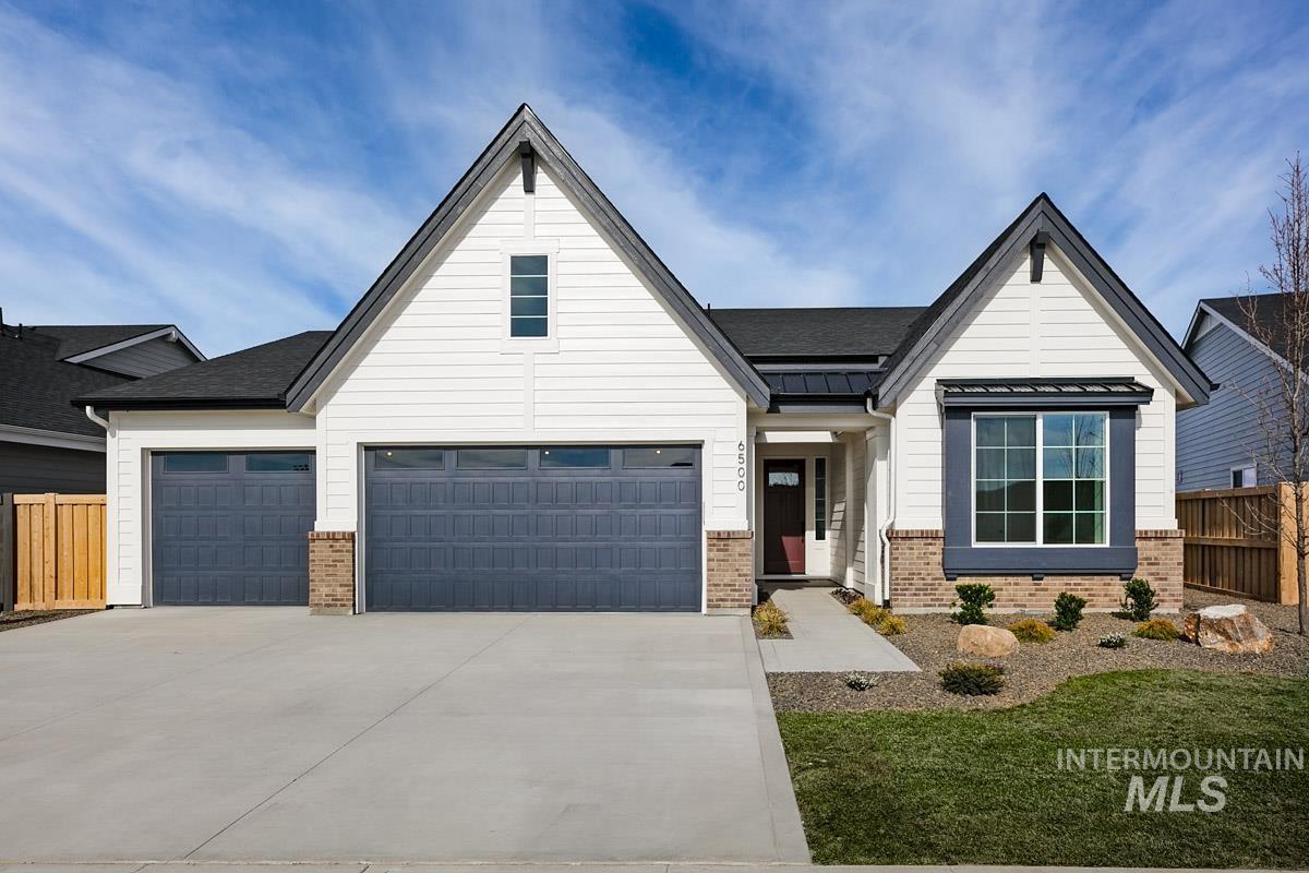 992 East Crescendo Street Meridian, ID 83642 - Photo 1 of 38 Modern farmhouse style home with brick siding, concrete driveway, a garage, a standing seam roof, and roof with shingles