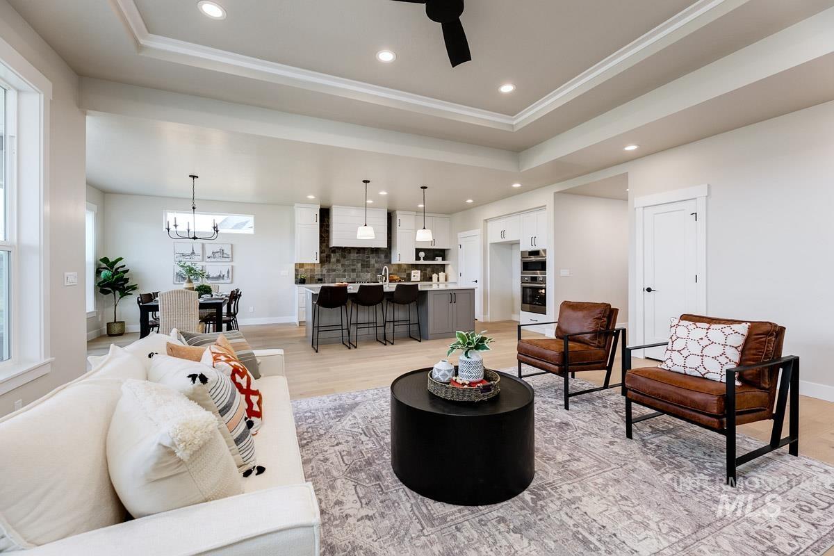 992 East Crescendo Street Meridian, ID 83642 - Photo 19 of 38 Living room with a tray ceiling, ceiling fan, light wood finished floors, and suspended lighting