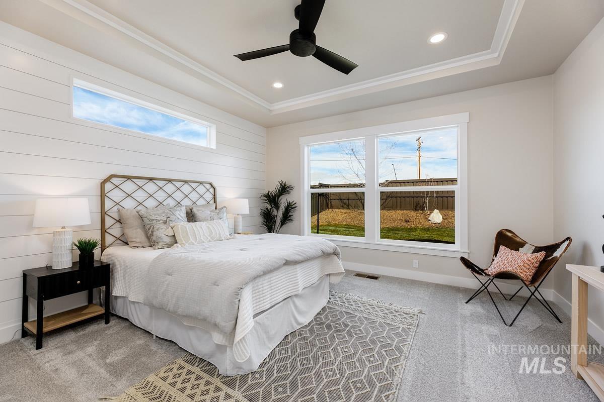 992 East Crescendo Street Meridian, ID 83642 - Photo 22 of 38 Bedroom with multiple windows, ceiling fan, light colored carpet, recessed lighting, and a tray ceiling