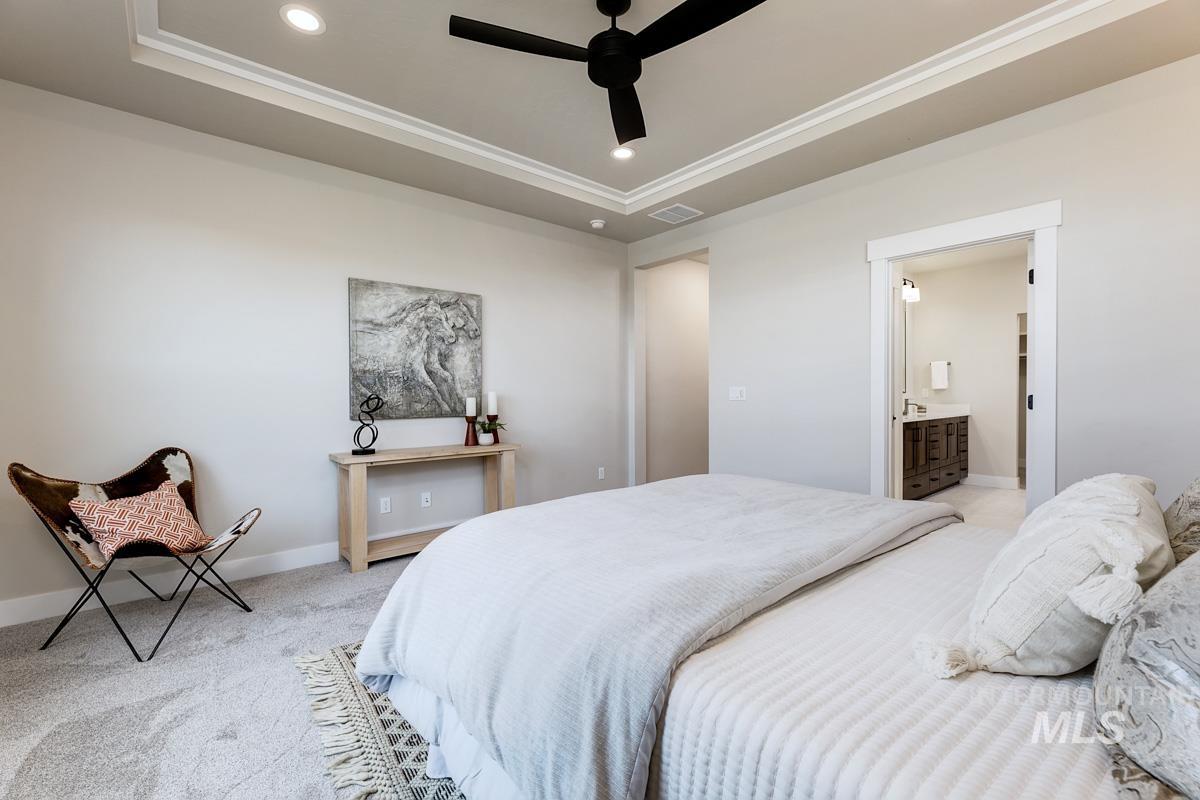 992 East Crescendo Street Meridian, ID 83642 - Photo 23 of 38 Bedroom with a raised ceiling, recessed lighting, ceiling fan, light colored carpet, and ensuite bath