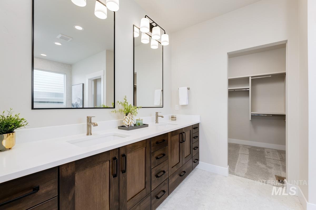 992 East Crescendo Street Meridian, ID 83642 - Photo 27 of 38 Full bathroom featuring double vanity, a walk in closet, and a chandelier