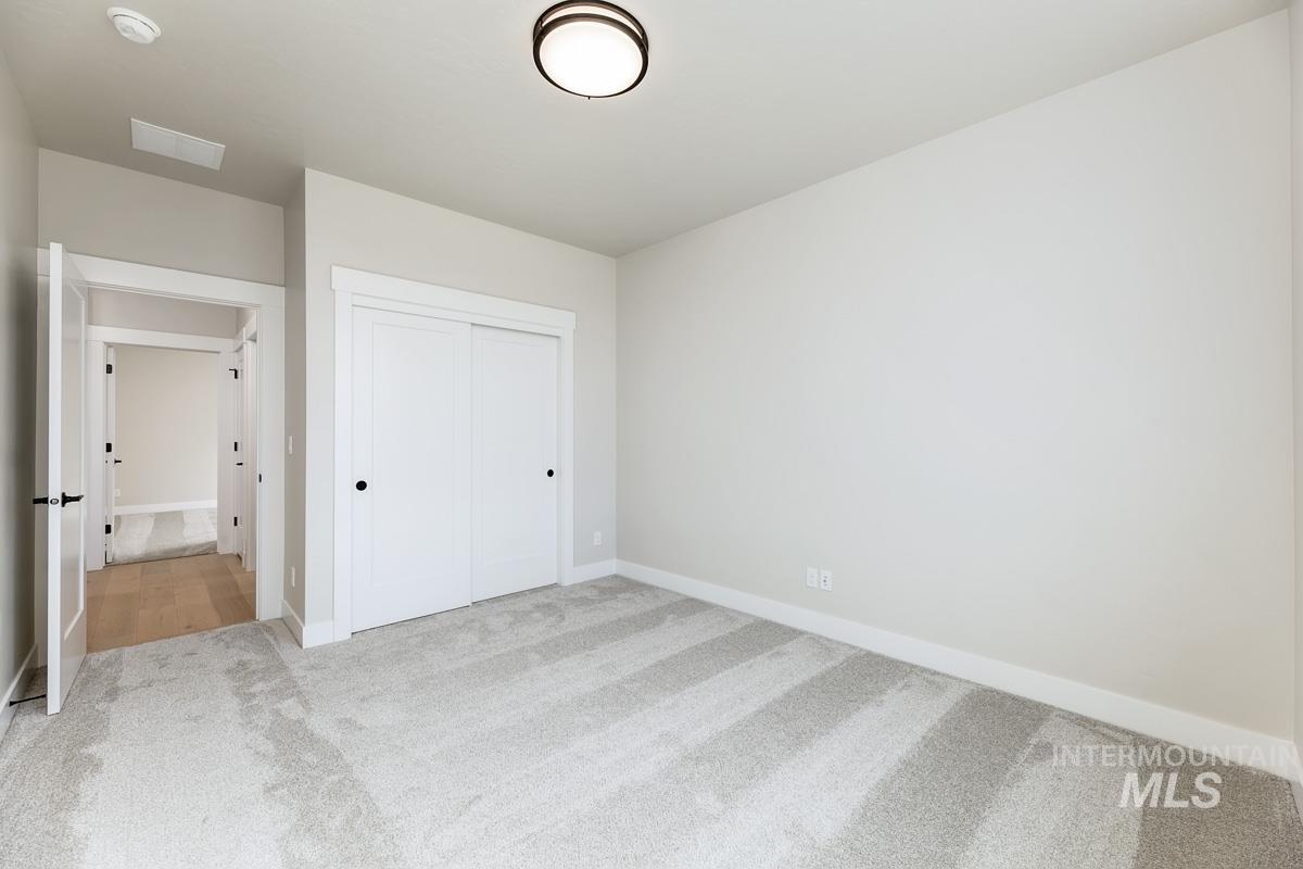 992 East Crescendo Street Meridian, ID 83642 - Photo 7 of 38 Unfurnished bedroom featuring light carpet and a closet