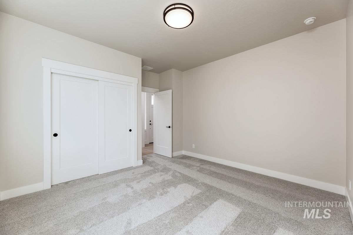 992 East Crescendo Street Meridian, ID 83642 - Photo 8 of 38 Unfurnished bedroom featuring light carpet and a closet