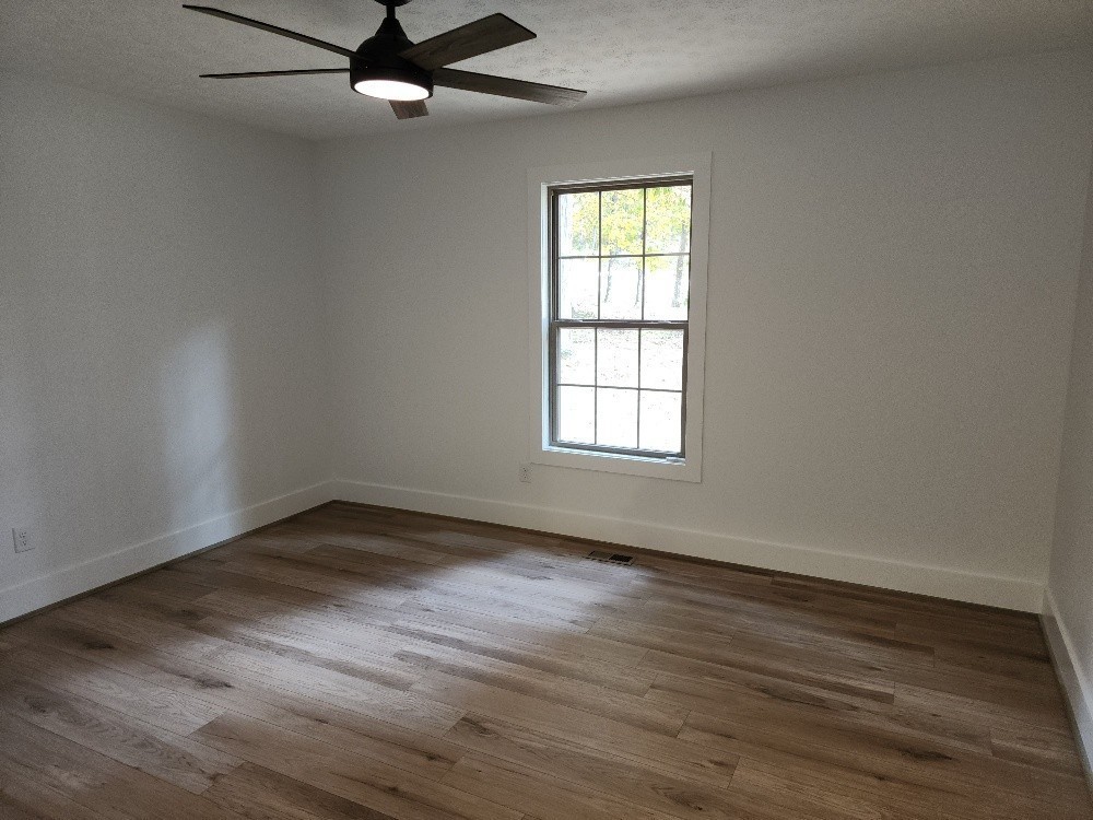 150 Hickory Ridge Lane Hartsville, TN 37074 - Photo 11 of 20 an empty room with wooden floor fan and windows