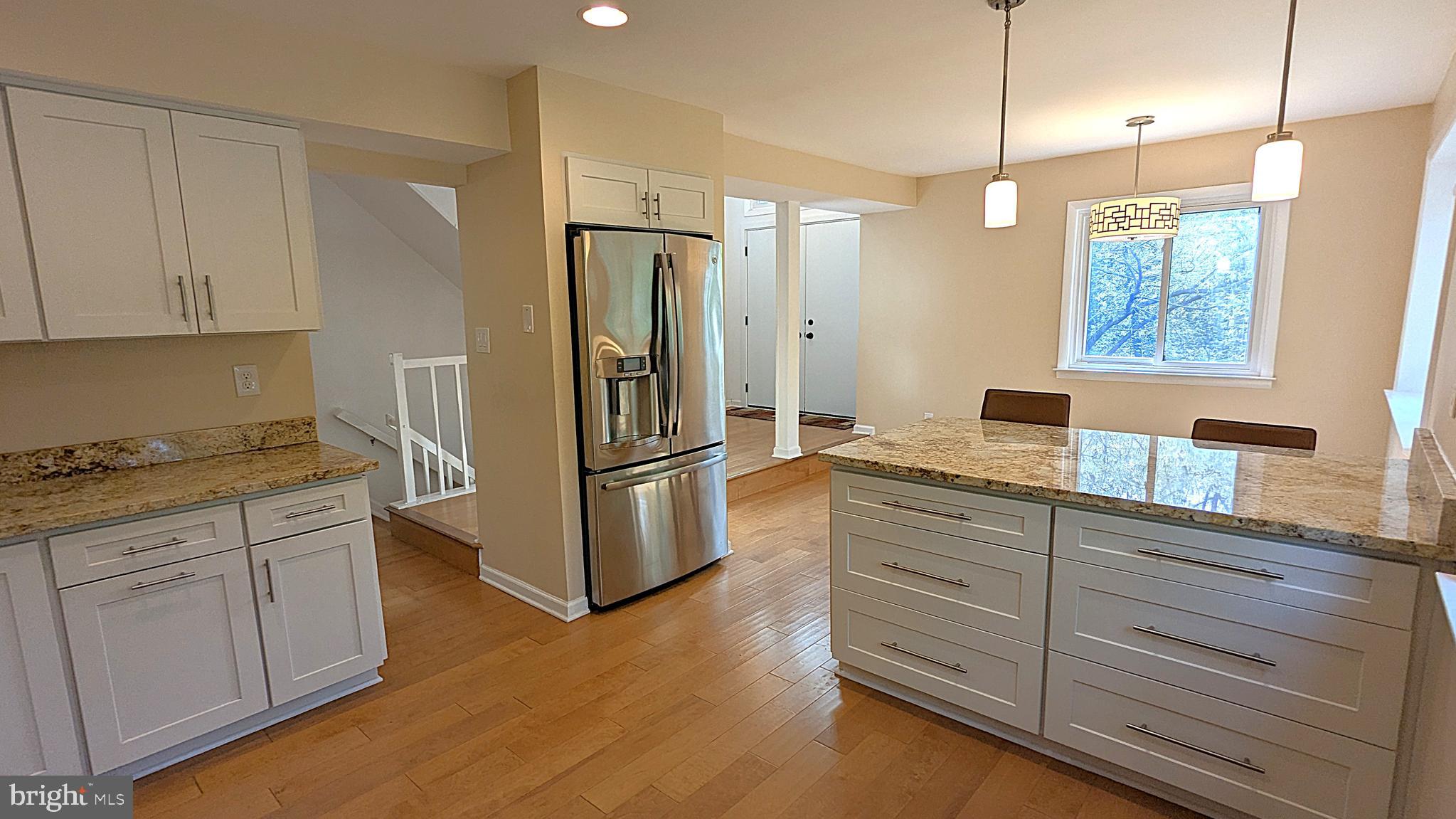 2200 Glencourse Lane Reston, VA 20191 - Photo 12 of 66 a kitchen with a refrigerator a sink and dishwasher with wooden floor