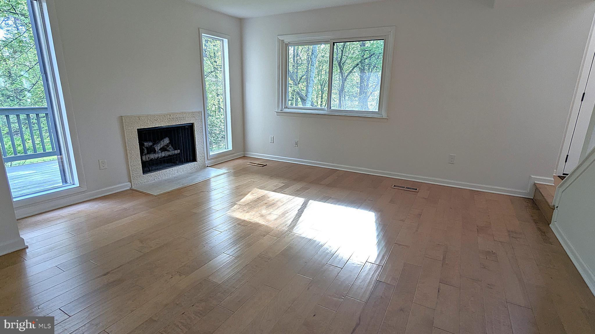 2200 Glencourse Lane Reston, VA 20191 - Photo 15 of 66 an empty room with wooden floor a fireplace and windows