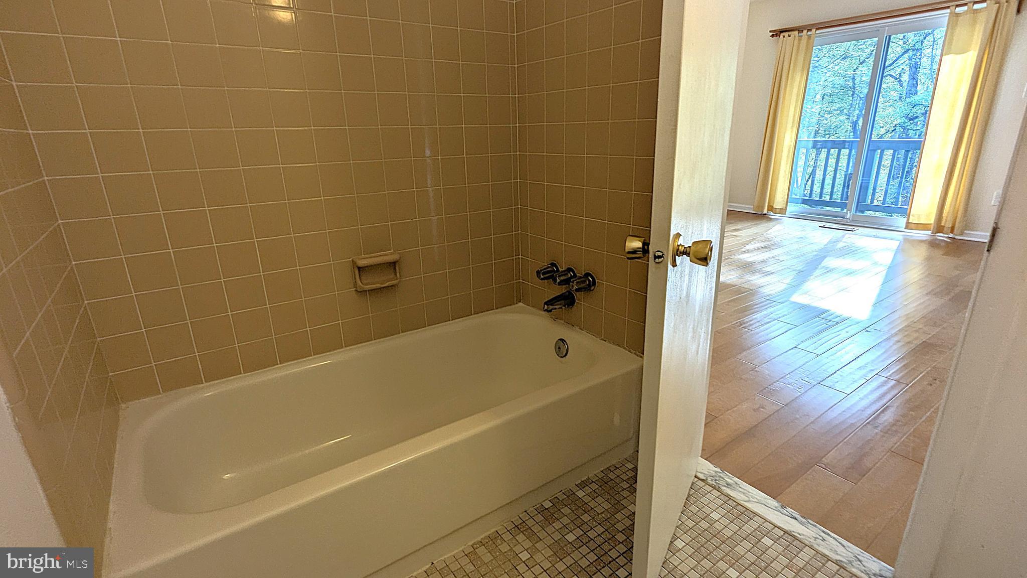 2200 Glencourse Lane Reston, VA 20191 - Photo 33 of 66 a bath tub sitting in a bathroom next to a window