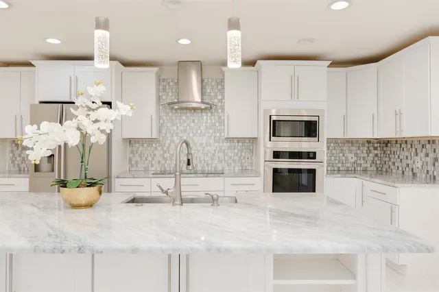 a kitchen with stainless steel appliances kitchen island granite countertop a sink a stove and cabinets