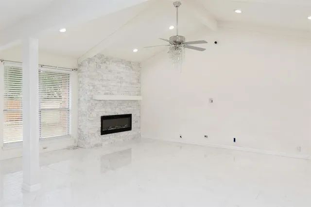 an empty room with windows and fireplace