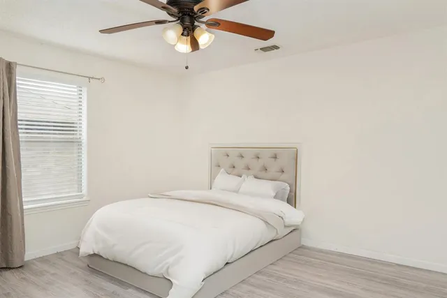 a bedroom with a large bed and a chandelier