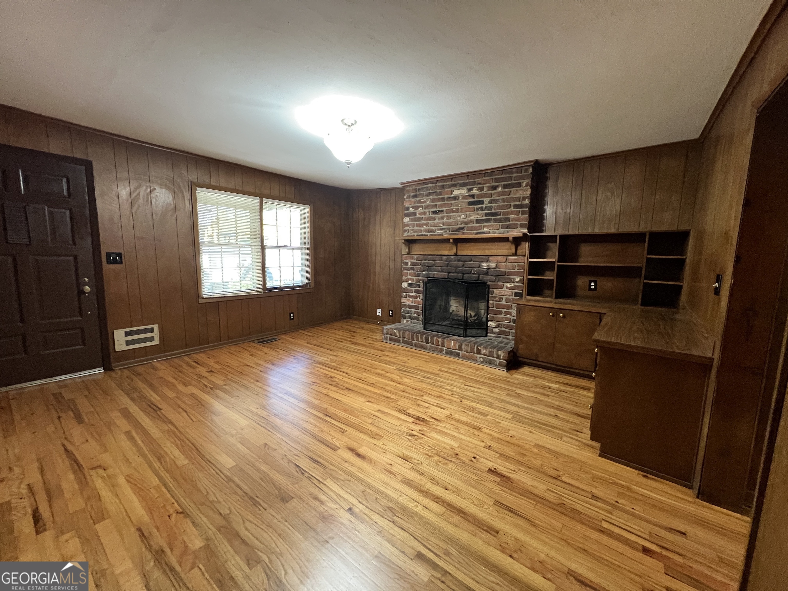 115 Old Stone Road Villa Rica, GA 30180 - Photo 15 of 18 an empty room with wooden floor fireplace and windows