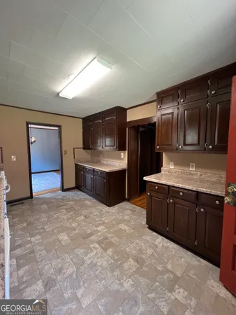 a large kitchen with kitchen island granite countertop a sink and cabinets