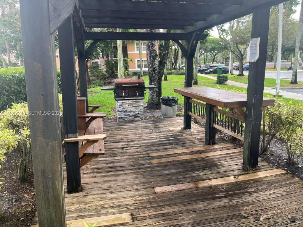 8701 Wiles Road, Unit 103 Coral Springs, FL 33067 - Photo 14 of 15 a view of a patio with a dining table chairs and a porch