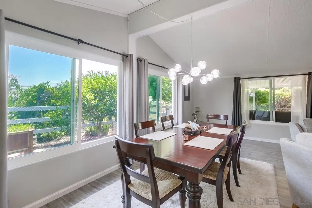 18218 Paradise Mountain Road, Unit 75 Valley Center, CA 92082 - Photo 13 of 68 a view of a dining room with furniture a chandelier and large windows