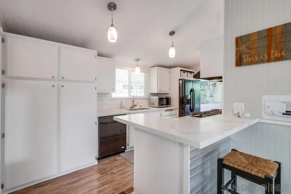 18218 Paradise Mountain Road, Unit 75 Valley Center, CA 92082 - Photo 15 of 68 a kitchen with kitchen island a sink appliances and cabinets