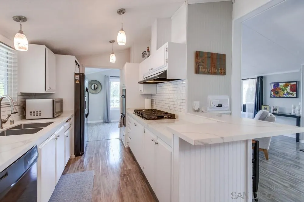 18218 Paradise Mountain Road, Unit 75 Valley Center, CA 92082 - Photo 16 of 68 a kitchen with stainless steel appliances a sink stove and cabinets
