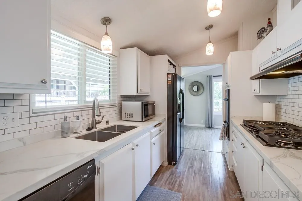 18218 Paradise Mountain Road, Unit 75 Valley Center, CA 92082 - Photo 17 of 68 a kitchen with a sink stove cabinets and wooden floor