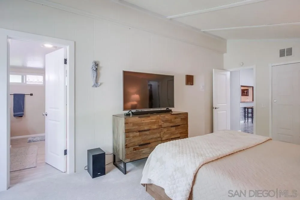 18218 Paradise Mountain Road, Unit 75 Valley Center, CA 92082 - Photo 31 of 68 a bedroom with a bed and a flat screen tv