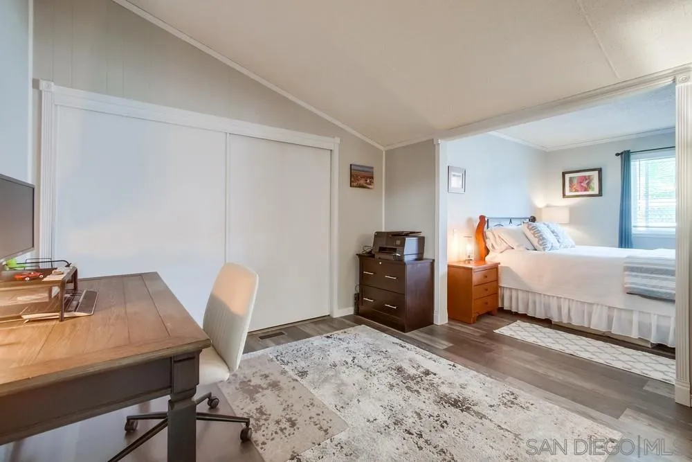 18218 Paradise Mountain Road, Unit 75 Valley Center, CA 92082 - Photo 36 of 68 a bedroom with a bed and a table in it