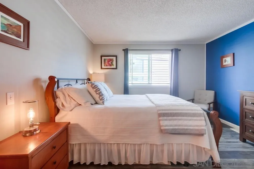 18218 Paradise Mountain Road, Unit 75 Valley Center, CA 92082 - Photo 38 of 68 a bedroom with a bed and wooden floor