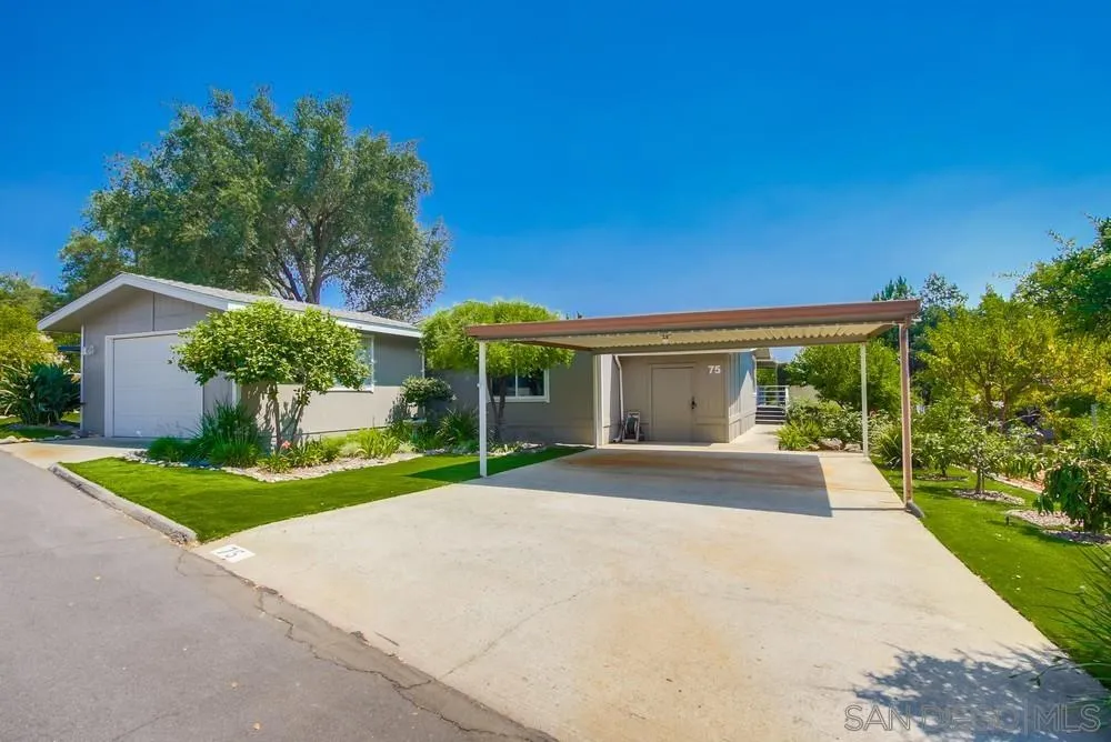 18218 Paradise Mountain Road, Unit 75 Valley Center, CA 92082 - Photo 4 of 68 a view of a house with palm trees and a yard