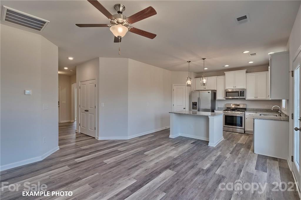 7392 Latham Way, Unit 6 Raleigh, NC 27604 - Photo 2 of 3 a kitchen with a refrigerator and white cabinets