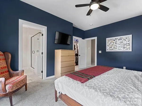 a bedroom with a bed and a refrigerator