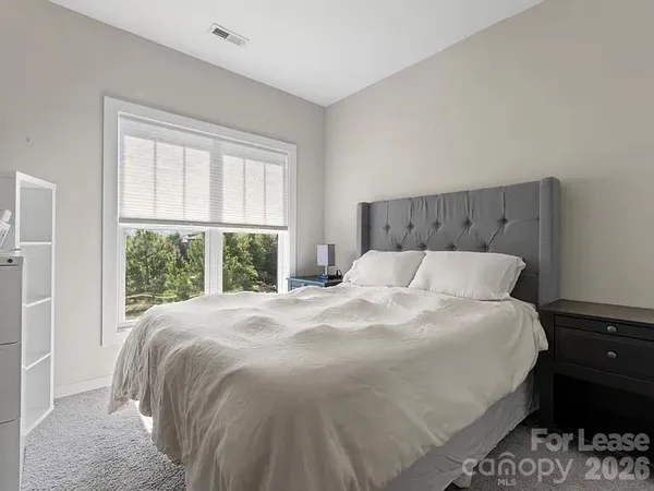 a large bed sitting in a bedroom next to a window
