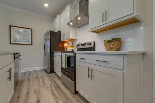 a kitchen with stainless steel appliances cabinets and a wooden floor