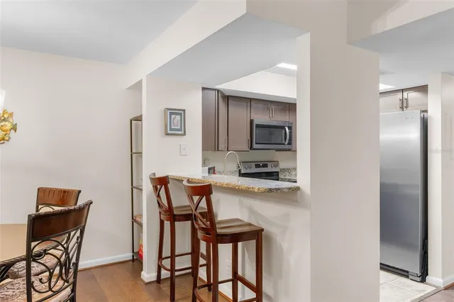 a kitchen with granite countertop a stove sink and refrigerator