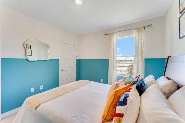 a bedroom with a bed and a painting on the wall