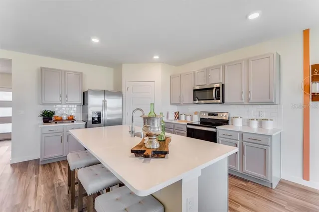 a kitchen with a sink a counter top space stainless steel appliances and cabinets