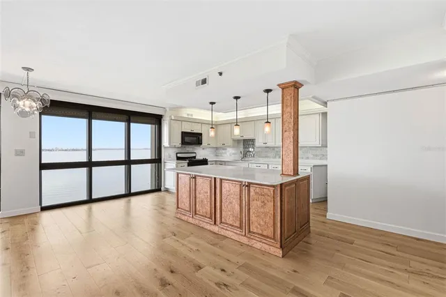 a kitchen with stainless steel appliances granite countertop a sink a stove and cabinets with wooden floor