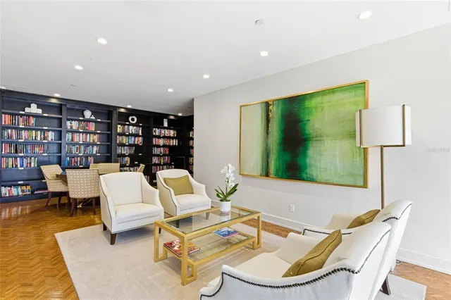 a view of swimming pool with a lounge chair and palm trees